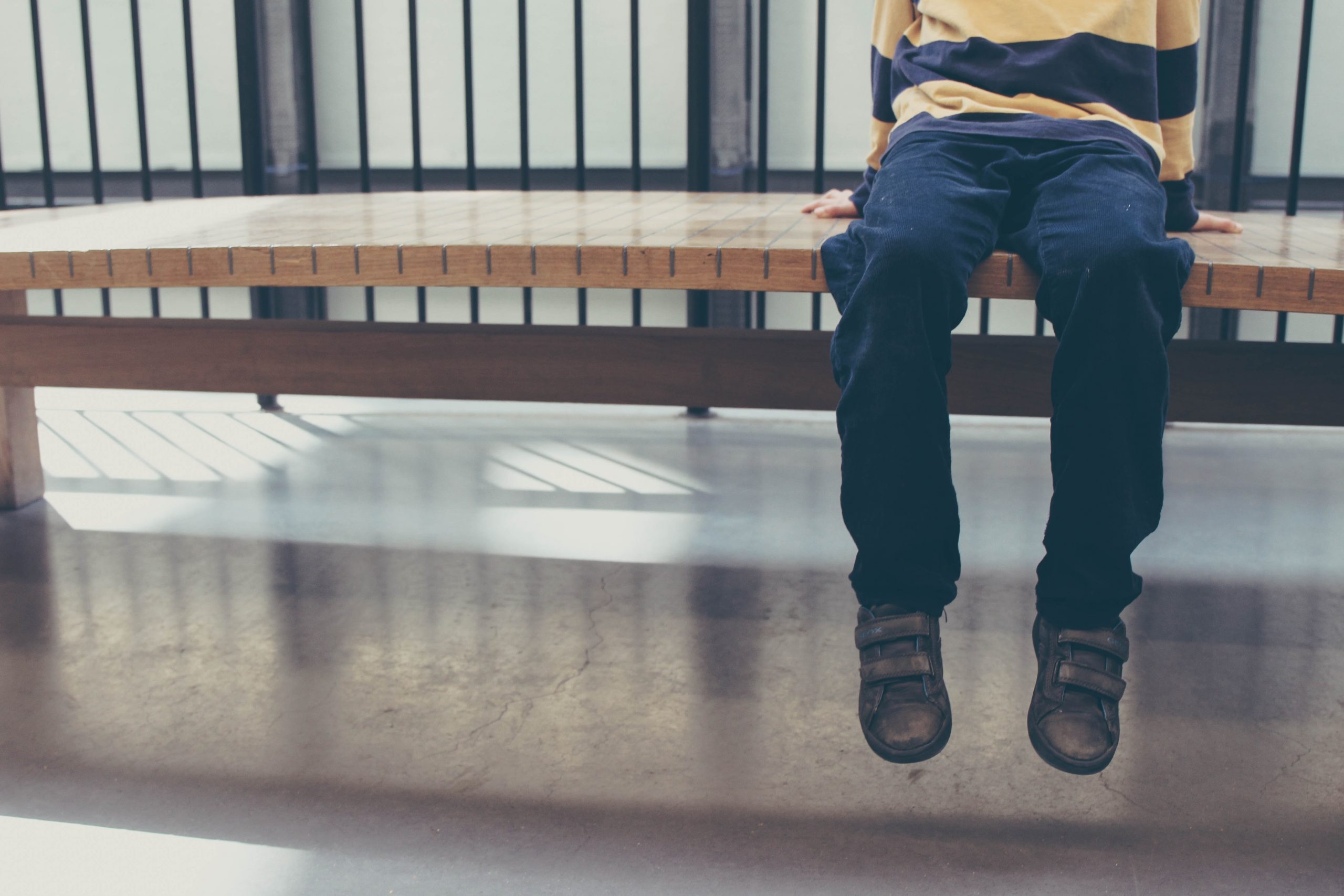 boy sitting alone on bench, no face, autism 