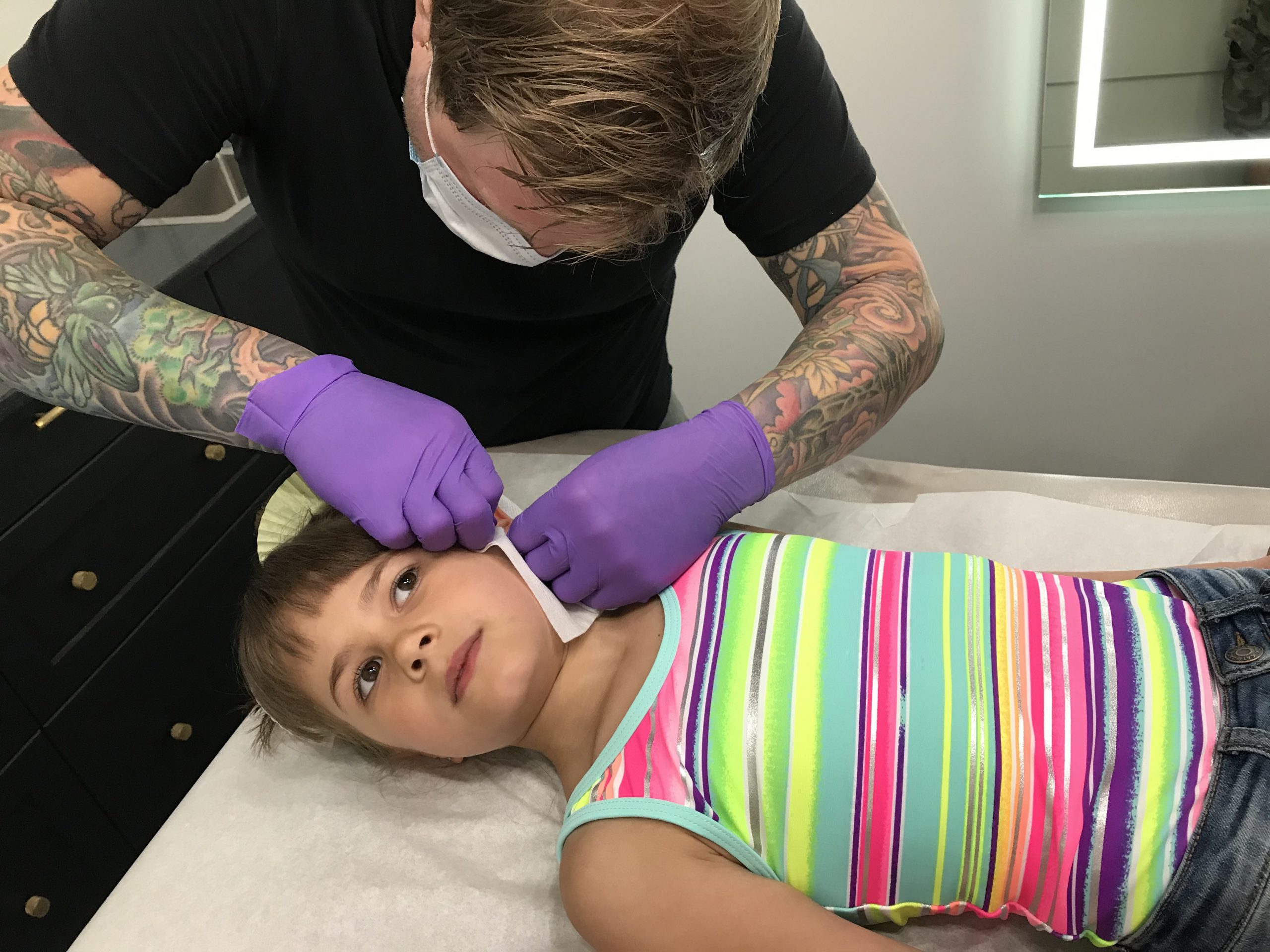 piercings, needle, ear piercings, earrings child getting an ear piercing