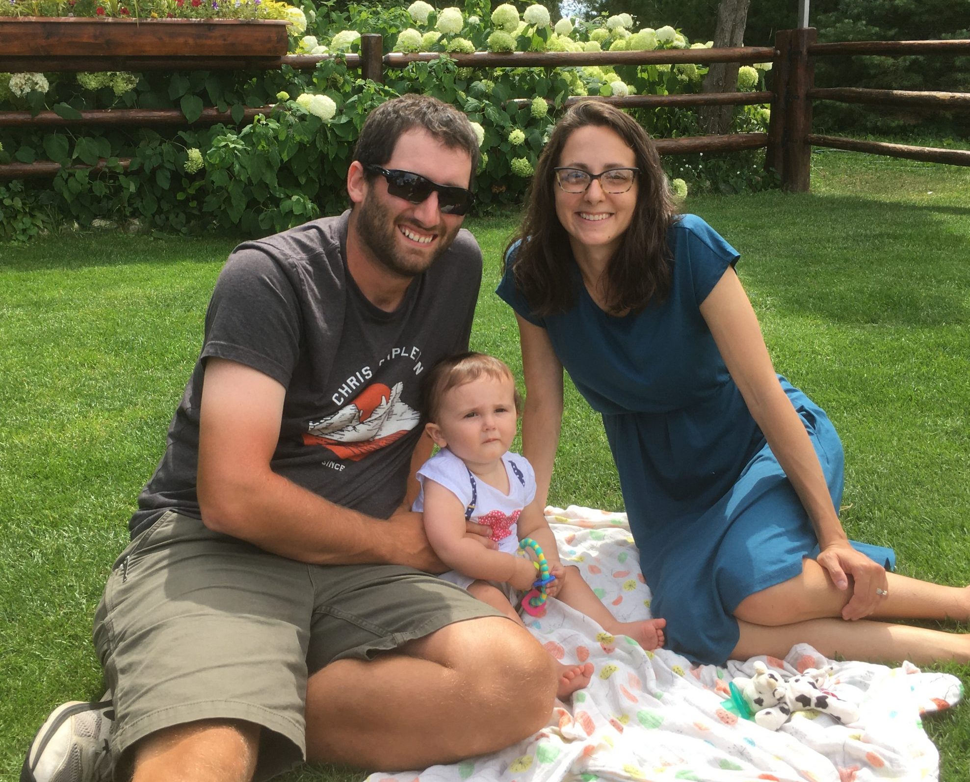 family of three on vacation, baby on blanket